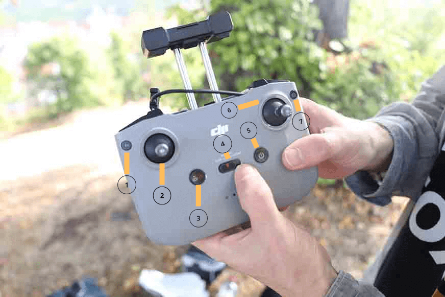 Der Controller der DJI Air 2S wird in der Hand gehalten und die Tastatur ist nummeriert.